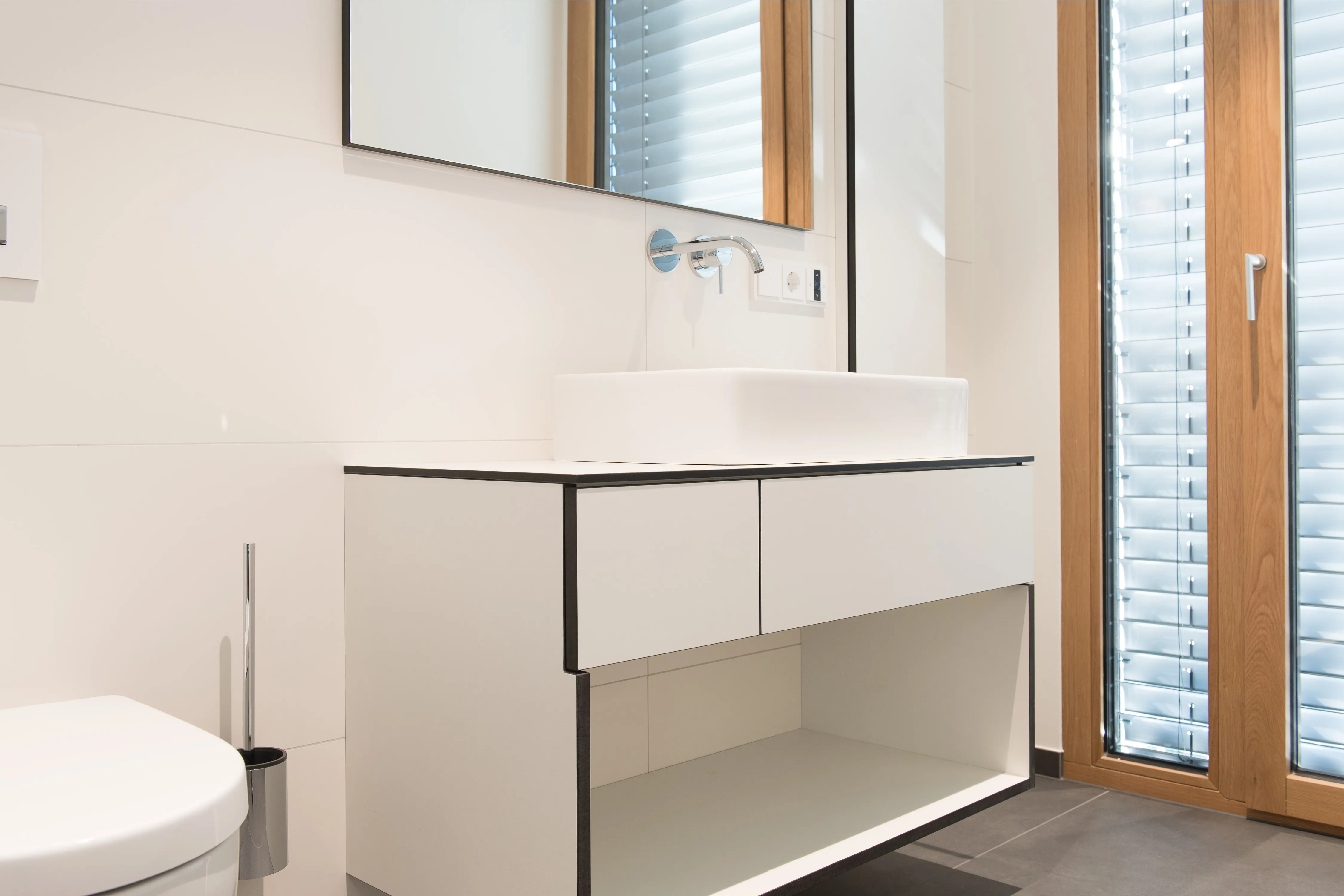 Modernes Gästebad mit weiß-schwarzem Waschtisch, rechteckigem Aufsatzbecken, Wandspiegel und Bodentiefen Fenster
