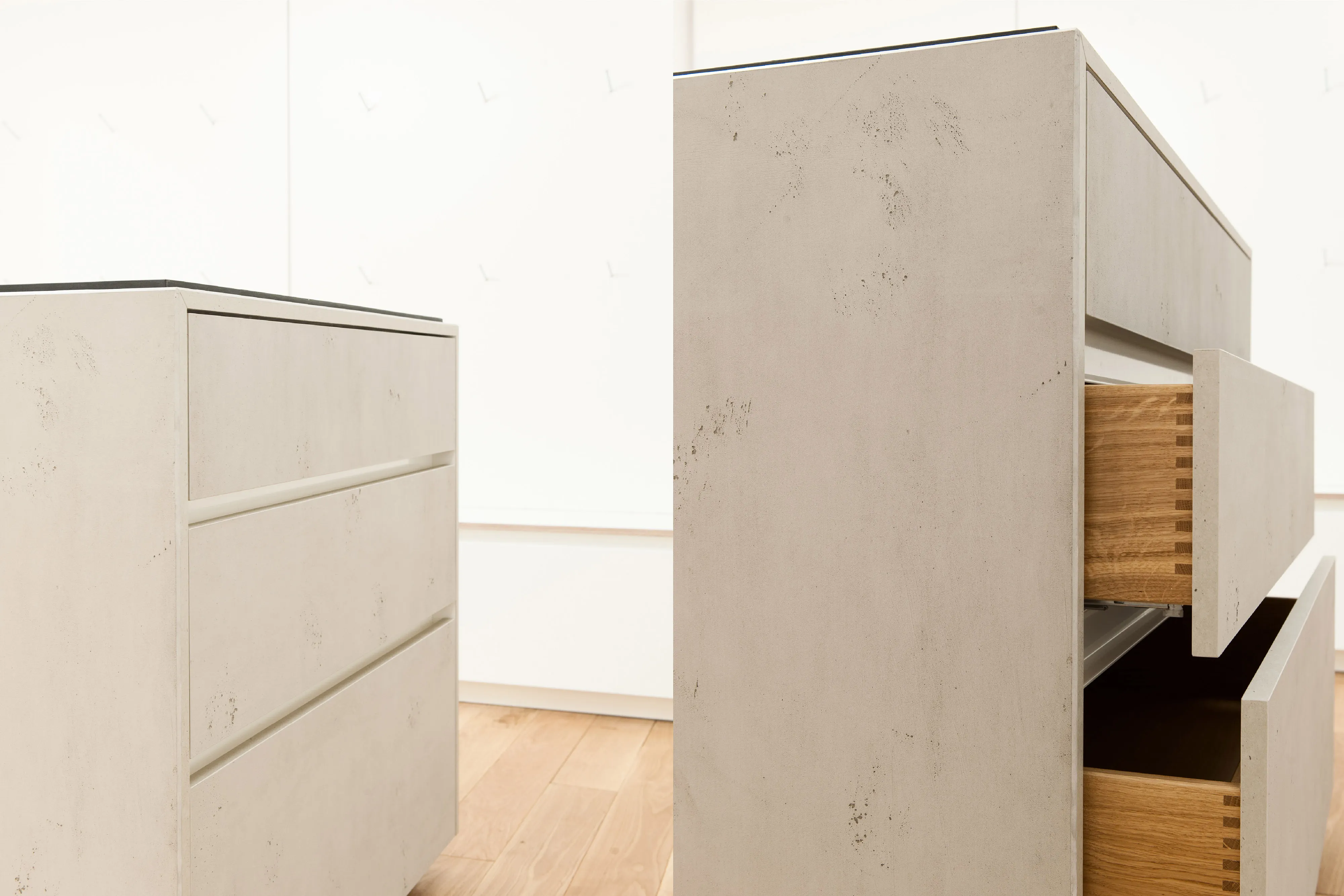 Geöffnete Schubladen einer maßgefertigten Kassen- oder Beratungstheke in Betonoptik mit klassisch gezinkten Holzkorpussen.