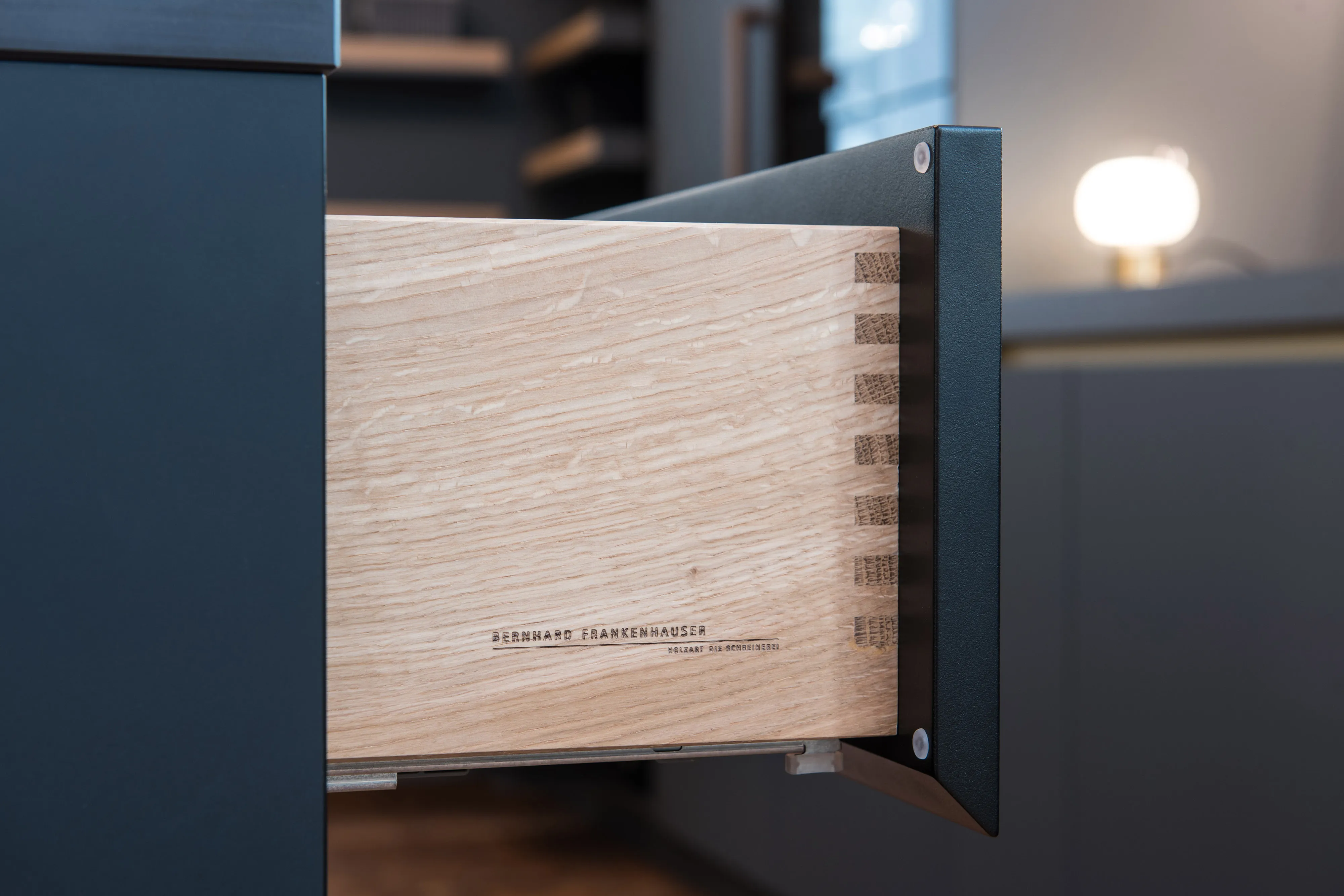 Offene Holzschublade mit Schwalbenschwanzzinkung und Brandstempel der Schreinerei Frankenhauser